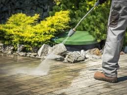 Professional pressure washing equipment cleaning concrete driveway